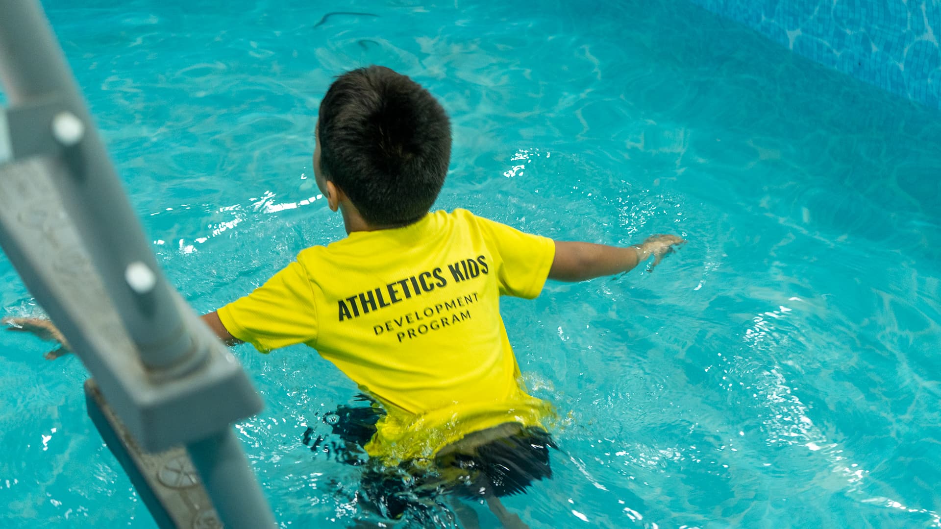 A child swimming across the Athletots aquatic room during a session