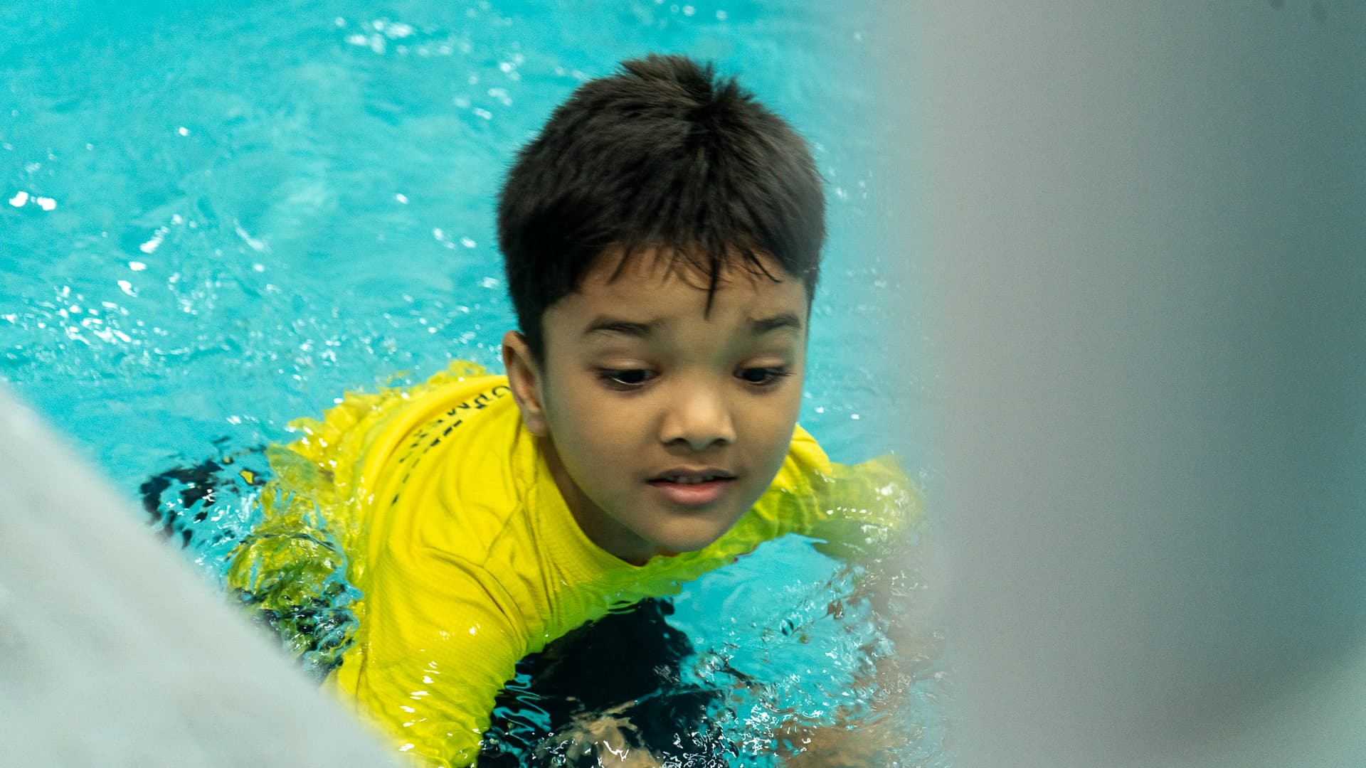 A child swimming during a session in the Athletots Aquatic Room, Pashan