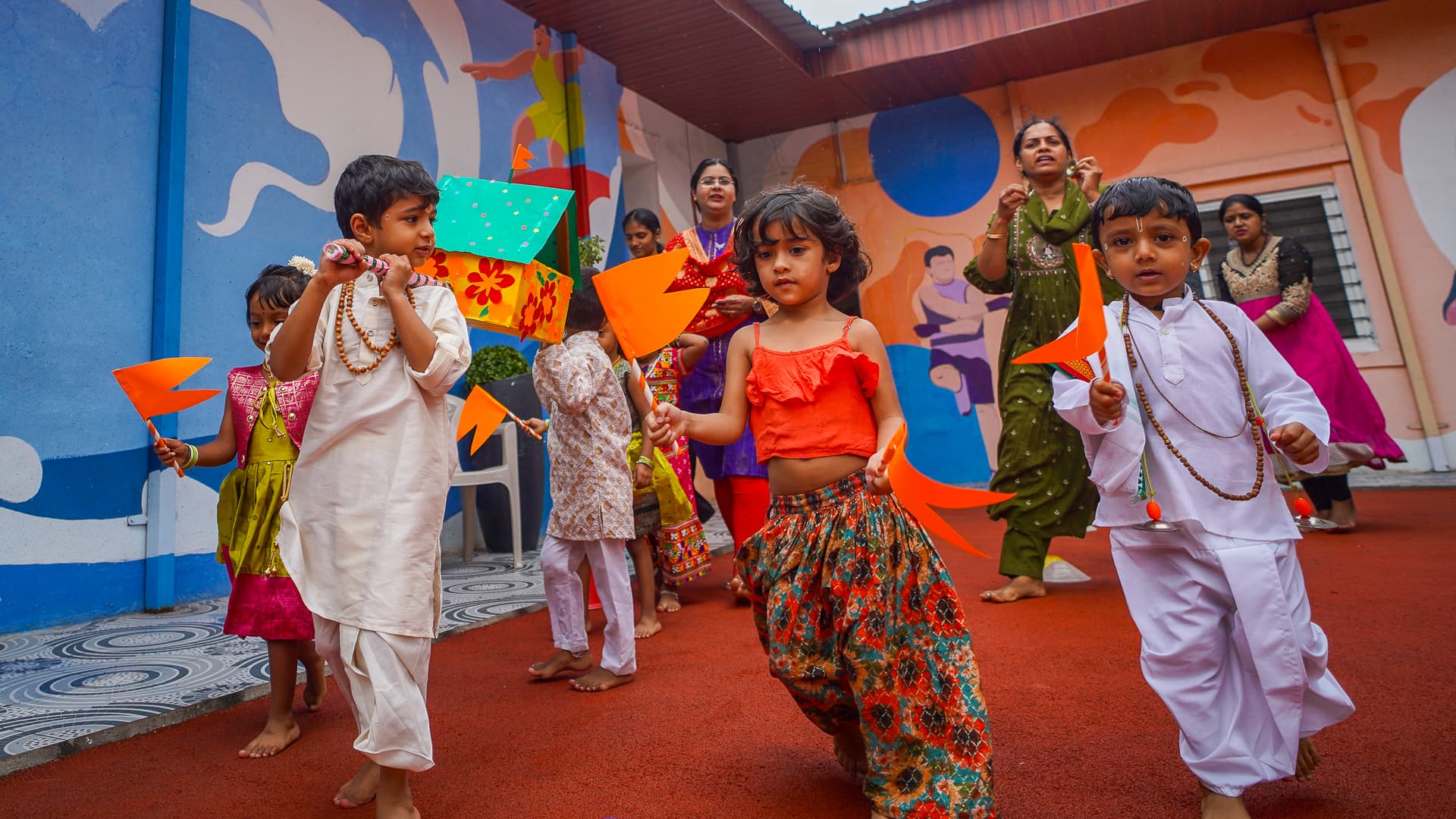 Athletots children dancing in festival costume across the campus courtyard