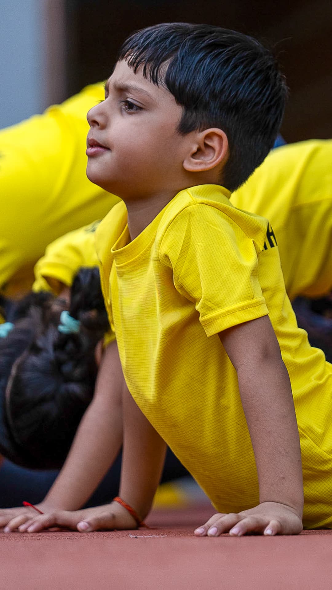 A child holding a cobra stretch during an outdoor yoga session