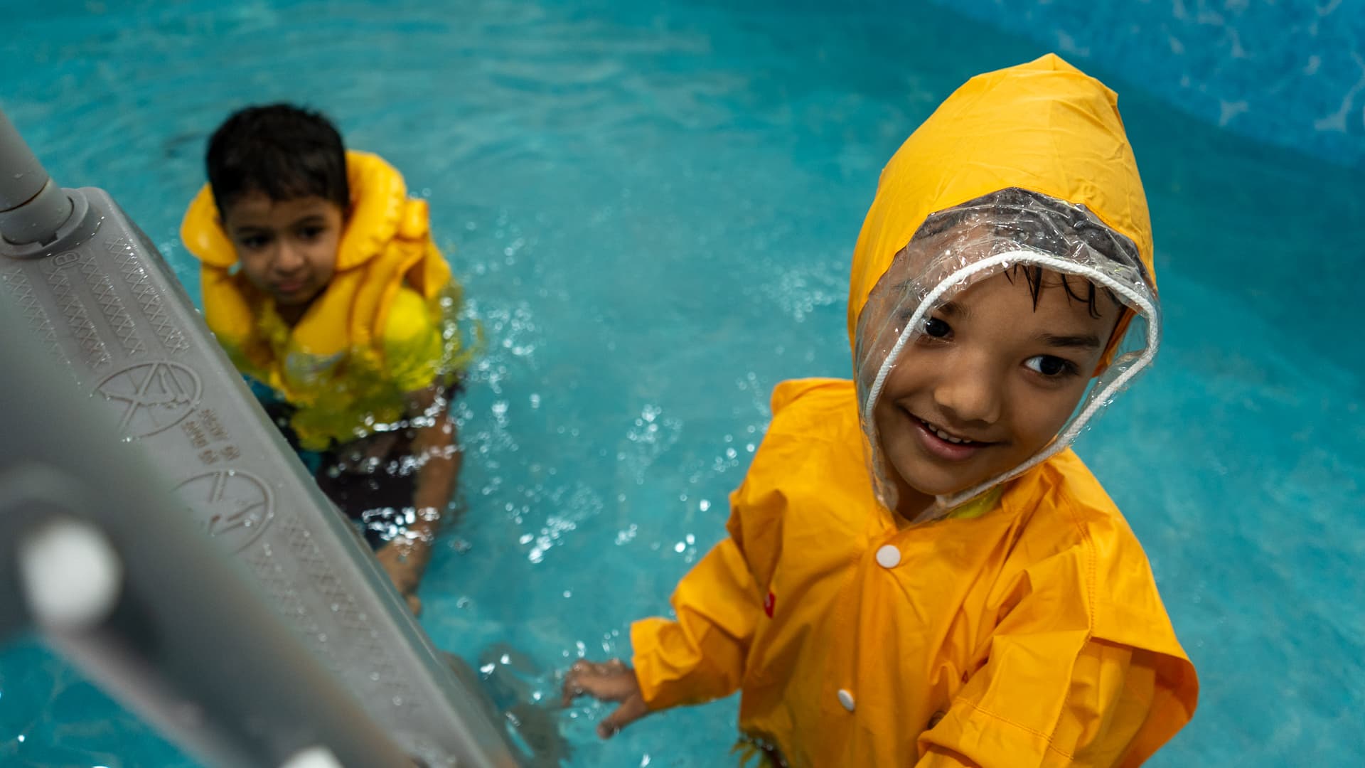 Two children in life jackets playing together in the Athletots aquatic room
