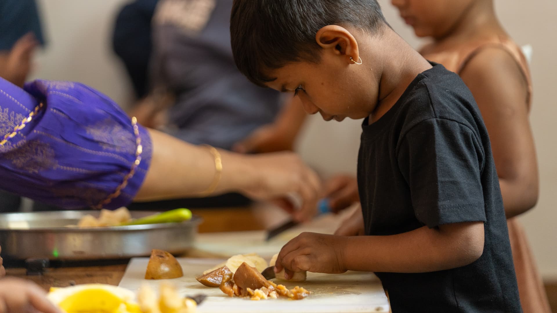 A child using a knife to prepare food in the Athletots nutrition lab
