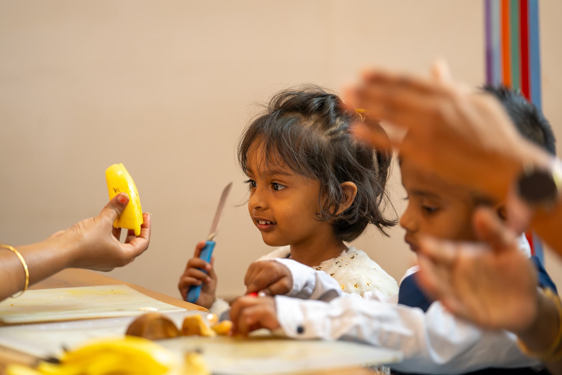 Pioneers children preparing fruit alongside a mentor in the nutrition lab